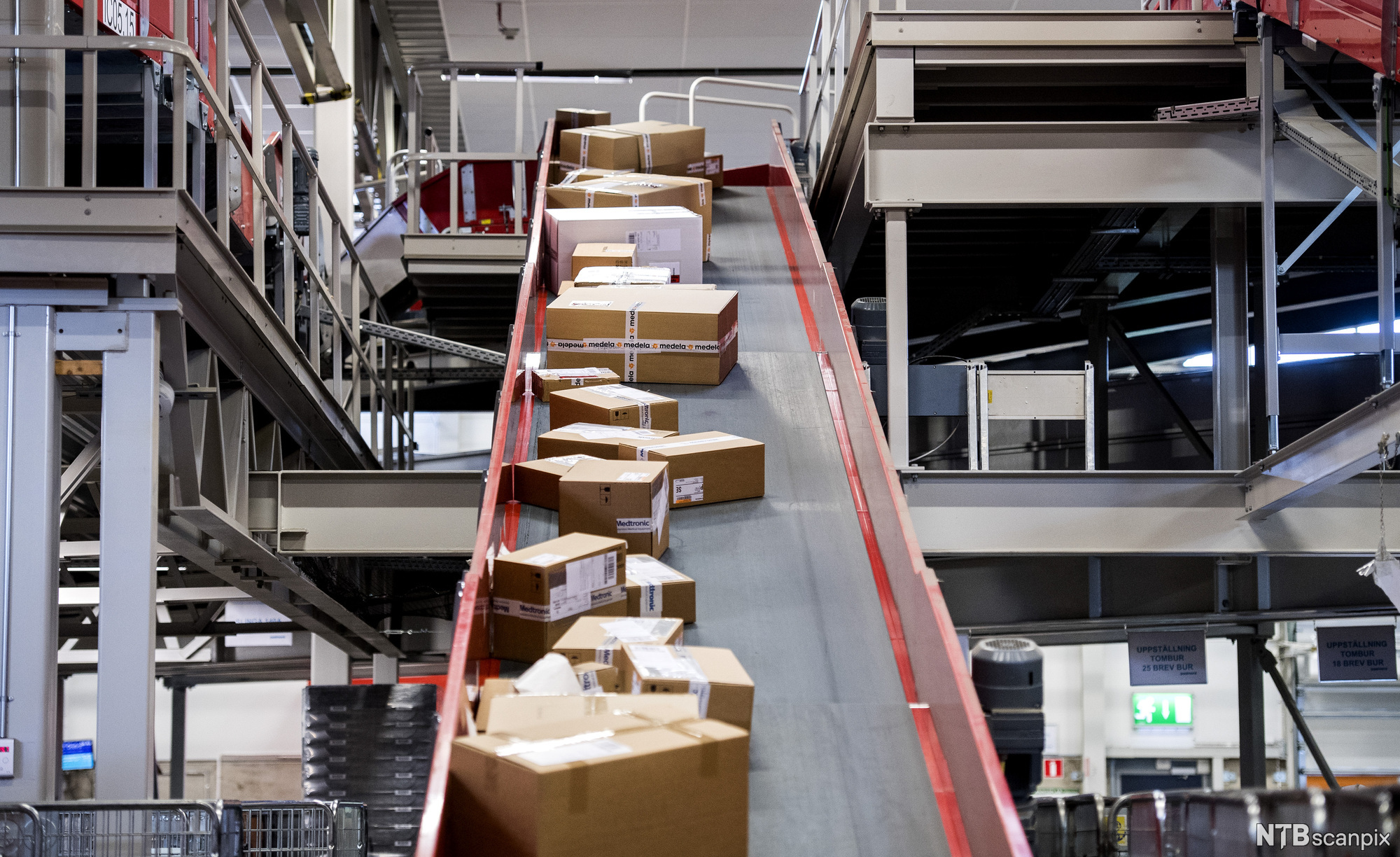 Pakker som fraktes på et transportbånd. Foto.