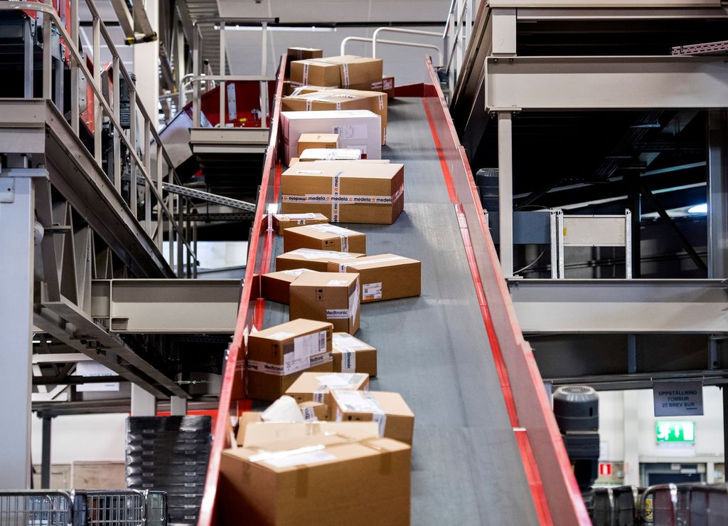 Pakker som fraktes på et transportbånd. Foto.