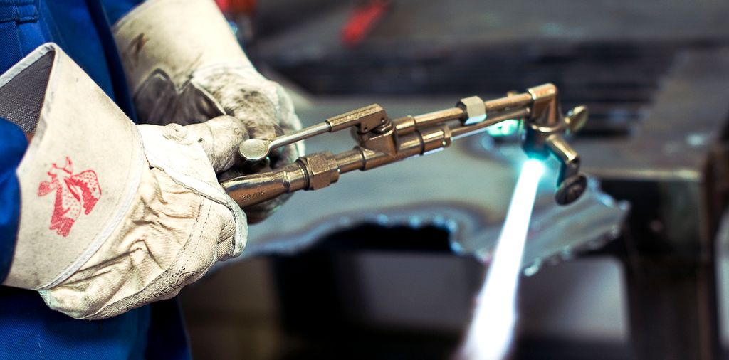 Person som holder en tent skjærebrenner med påmonterte løpehjul. Foto.