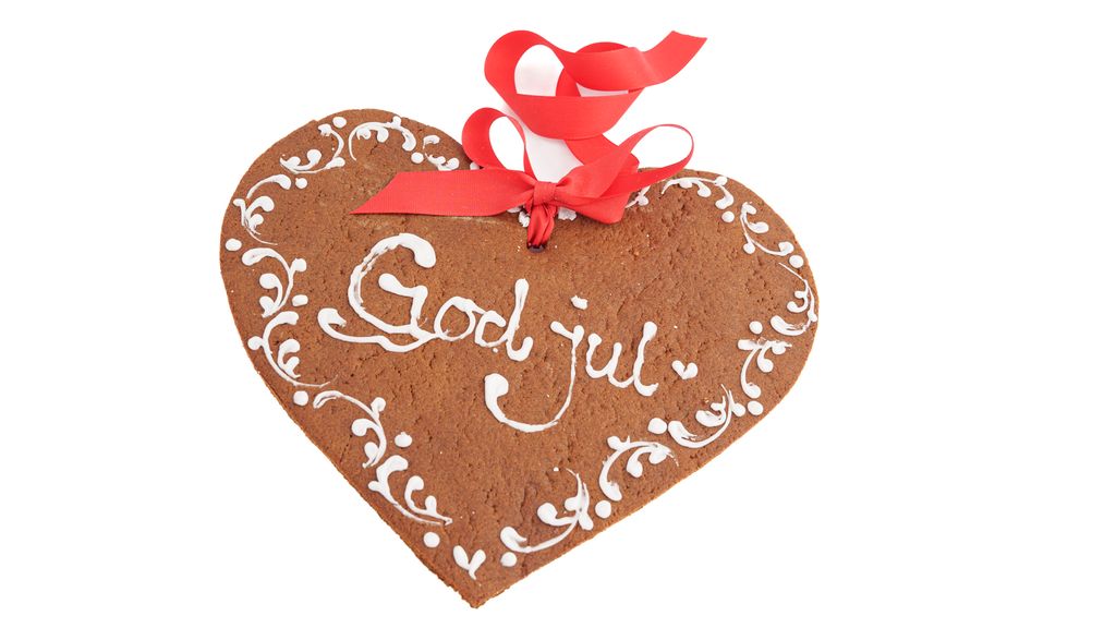 Et pent pyntet pepperkakehjerte med teksten" God jul" og en rød sløyfe. Foto.