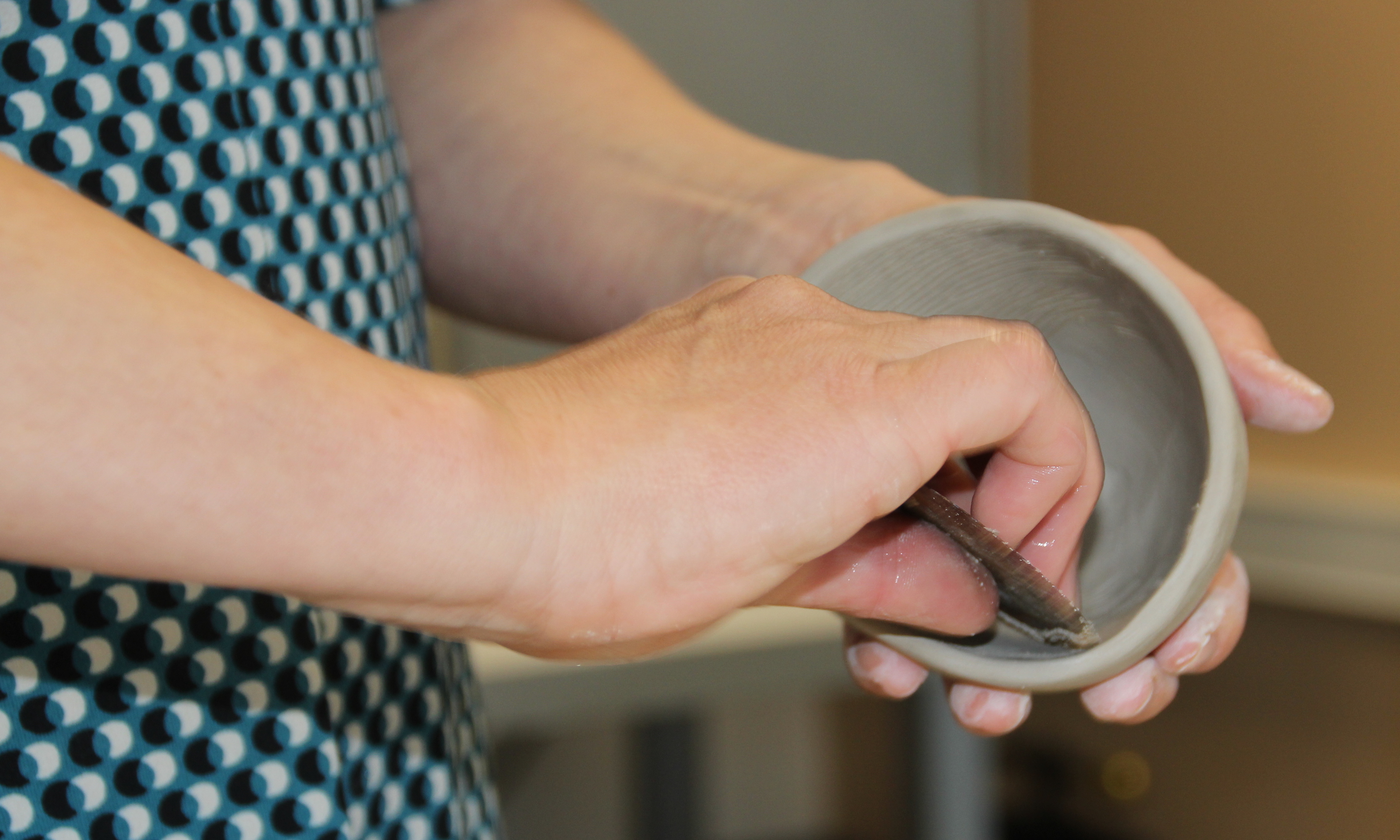 Forming av ein knipebolle i leire. Foto.