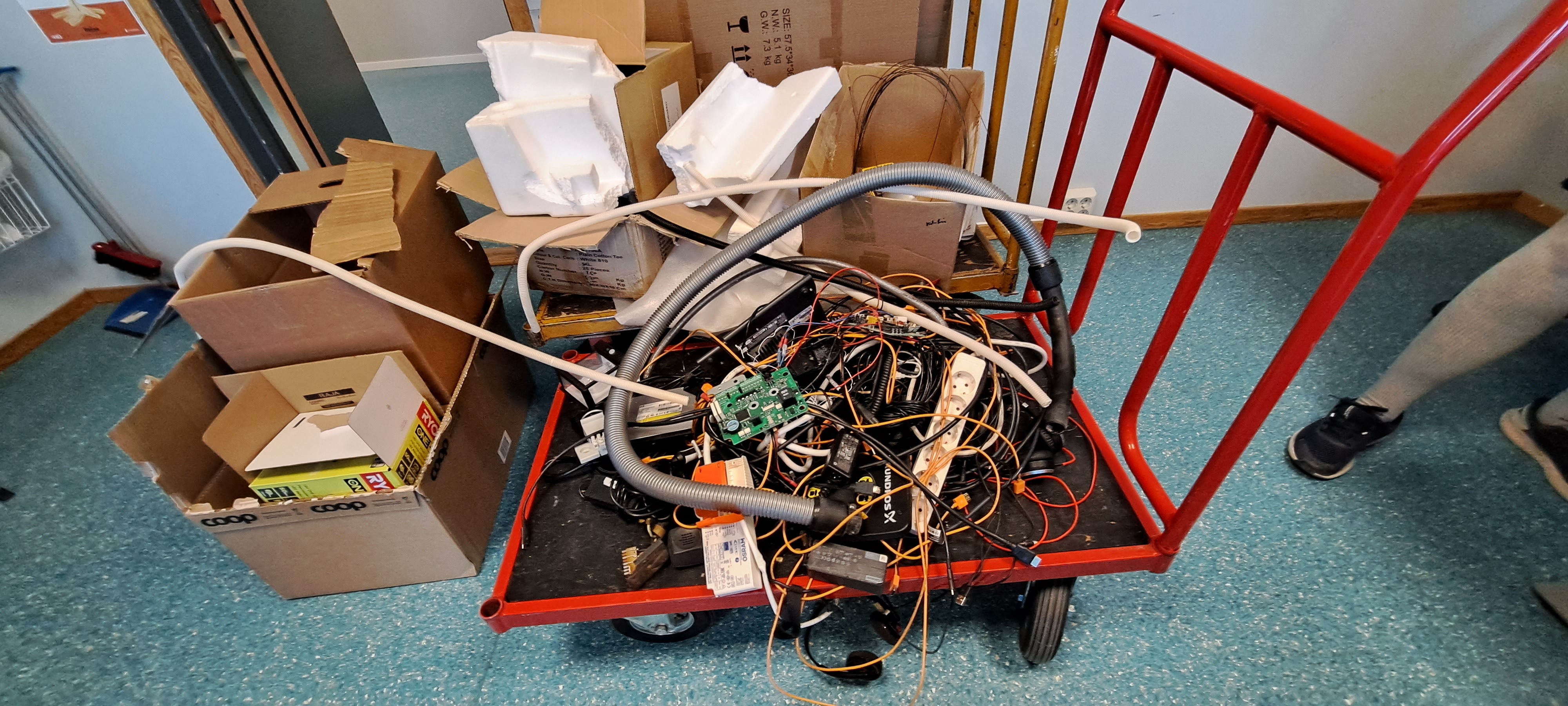 Tralle med elektronisk avfall, papp og isopor. Foto.