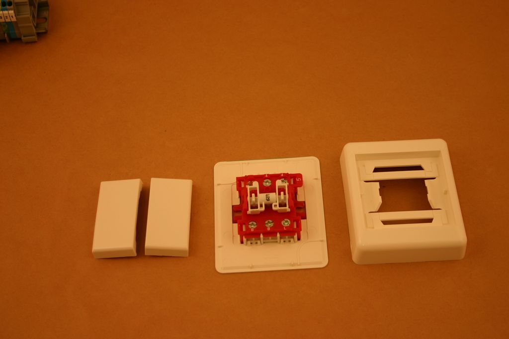 En serievender i deler. Delene indikerer at den skal brukes på vegg i et åpent anlegg. Innmaten i bryteren vil uansett være lik for en innfelt bryter. Foto.