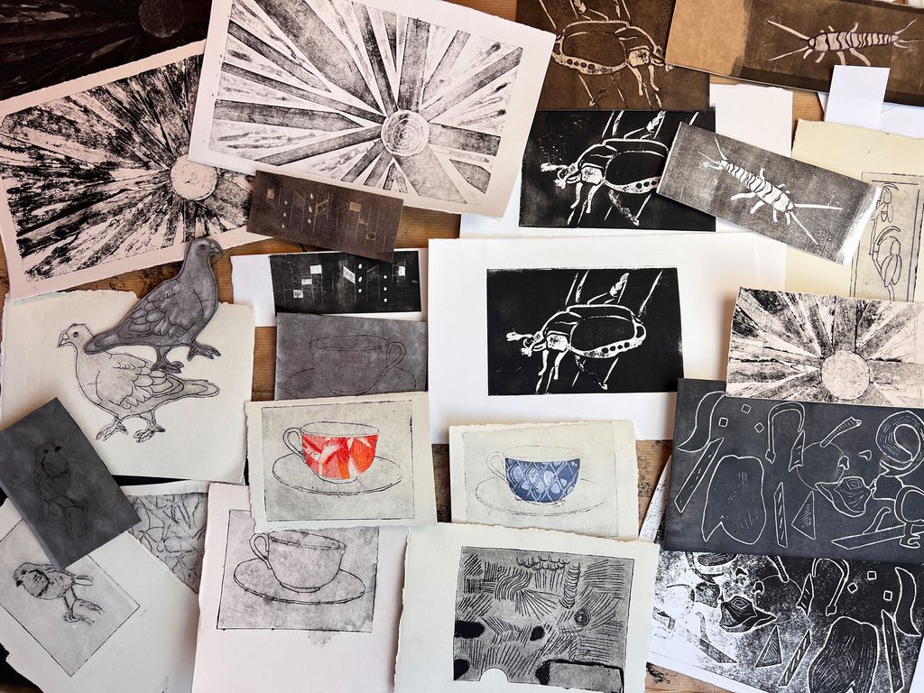 Mange trykkbilete ligg side om side. Foto.