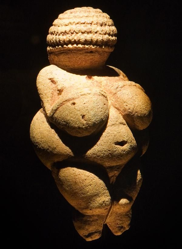 Skulptur av frodig kvinneskikkelse i sandstein. Foto.