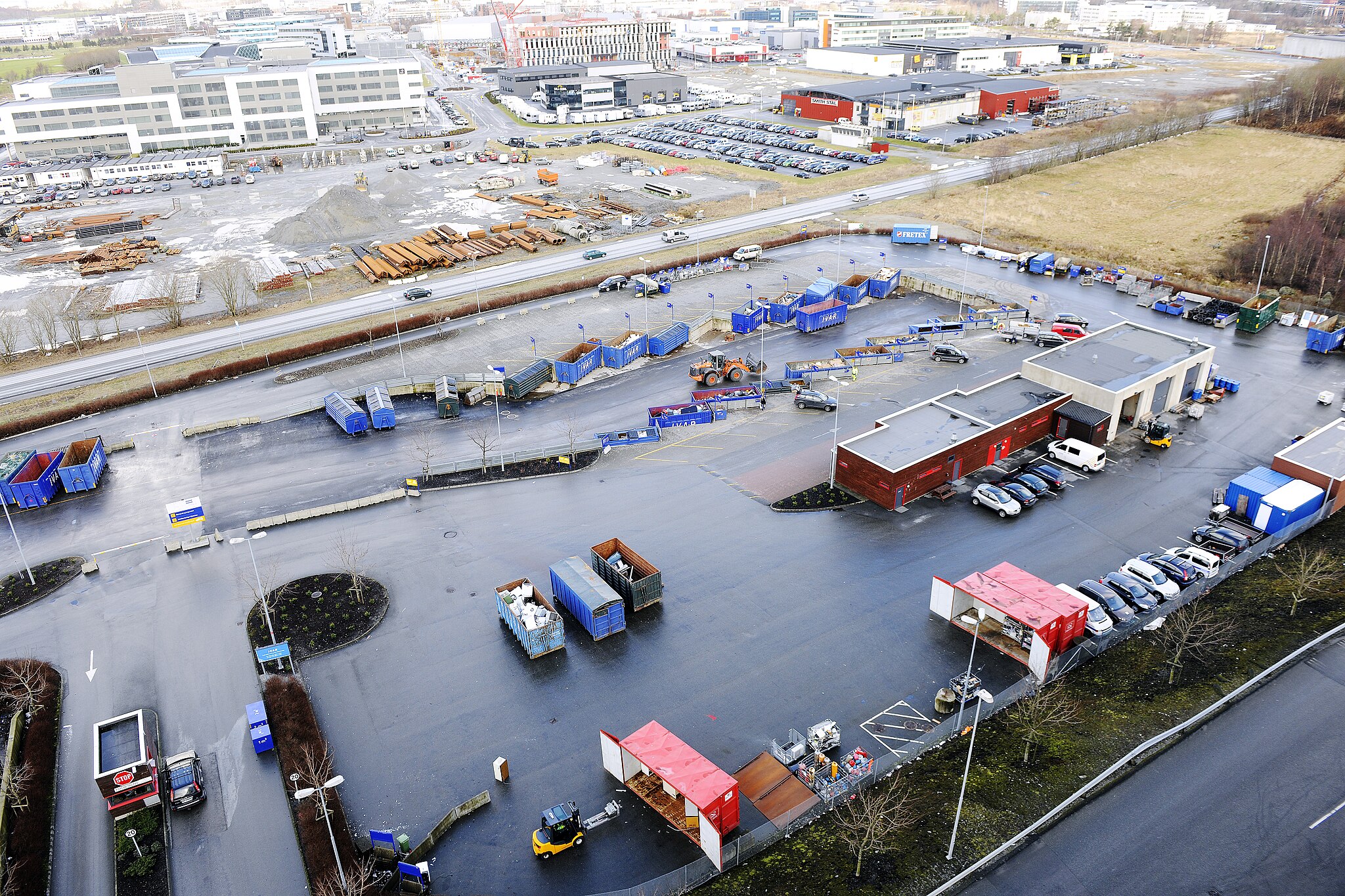 Oversiktsbilete av gjenvinningsstasjon med ulike konteinarar for innlevering av ulike typar avfall. Foto. 