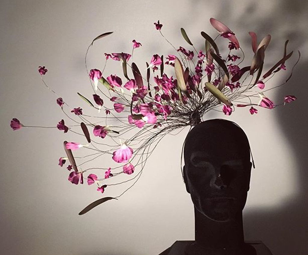 Byste med et hodeplagg laget av ståltråder og blomster. Foto.