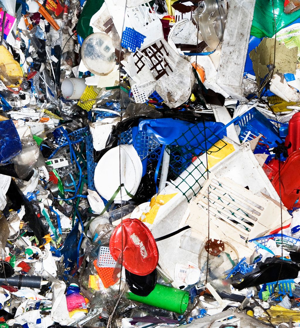 Plastavfall i mange fargar og former pressa saman. Foto.
