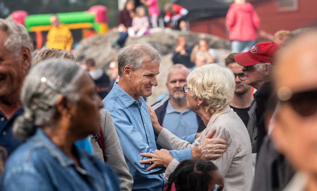 Partileder Jonas Gahr Støre i nær dialog med eldre kvinne midt i en folkemengde. Foto.