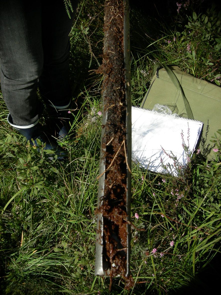 Metallsylinder med åpning i hele lengderetningen er fylt med jord. Foto.