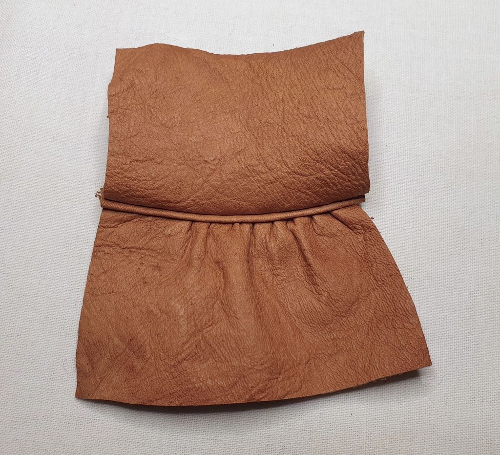 Fotografi av skinndeler som er sydd sammen med mellomlegg og rynkesøm.