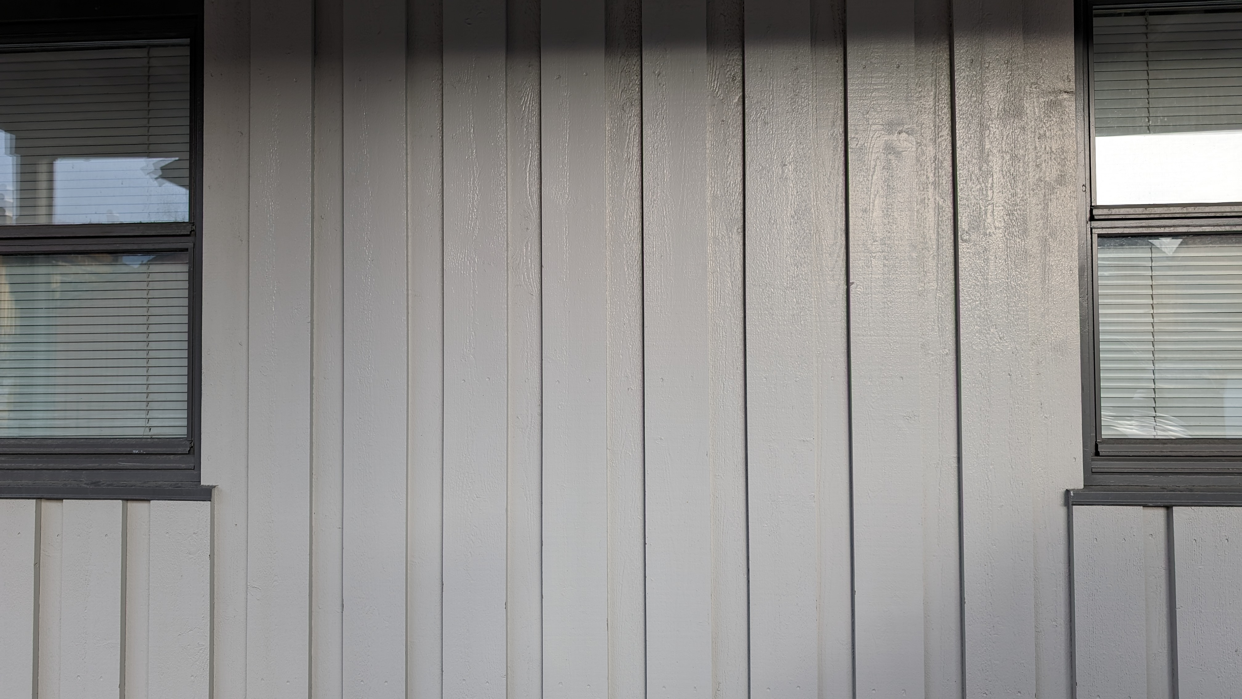 Veggen på et hus der det er montert tømmermannskledning med over- og underliggere. Foto.