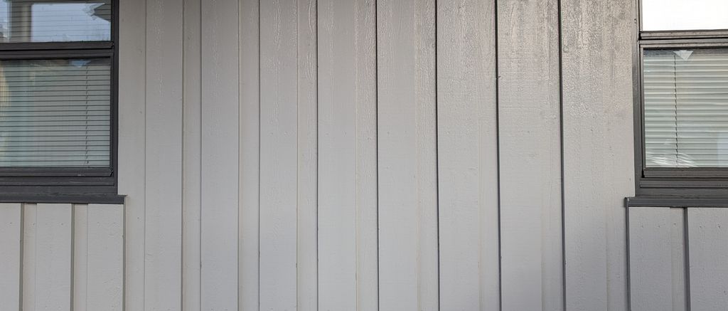 Veggen på et hus der det er montert tømmermannskledning med over- og underliggere. Foto.