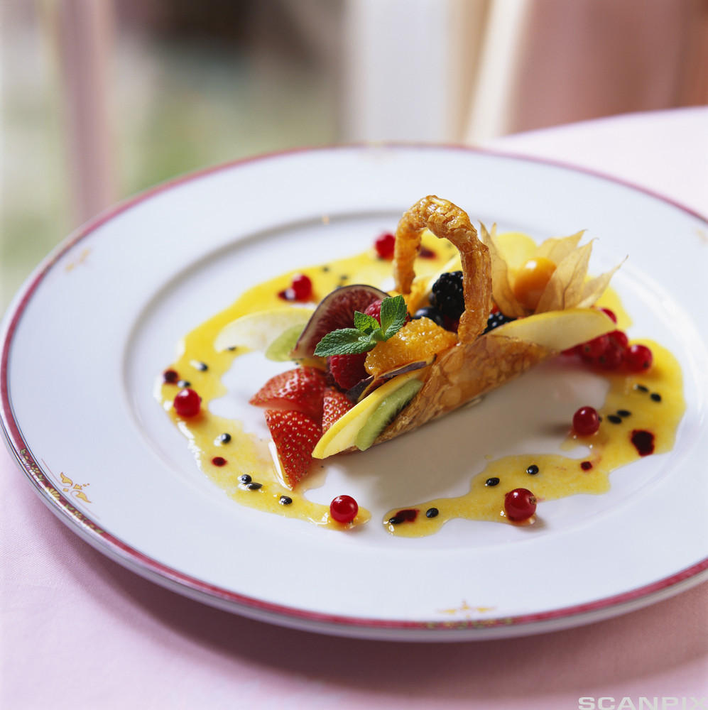 En liten fruktsalat pent dandert på en tallerken. Foto.