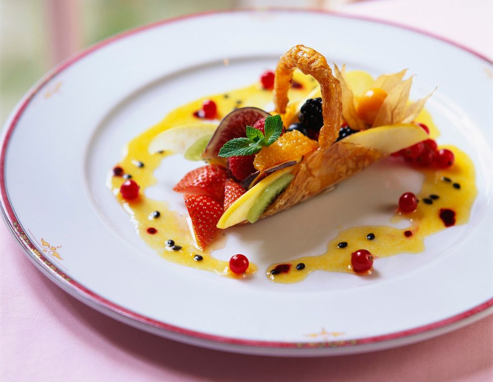 En liten fruktsalat pent dandert på en tallerken. Foto.