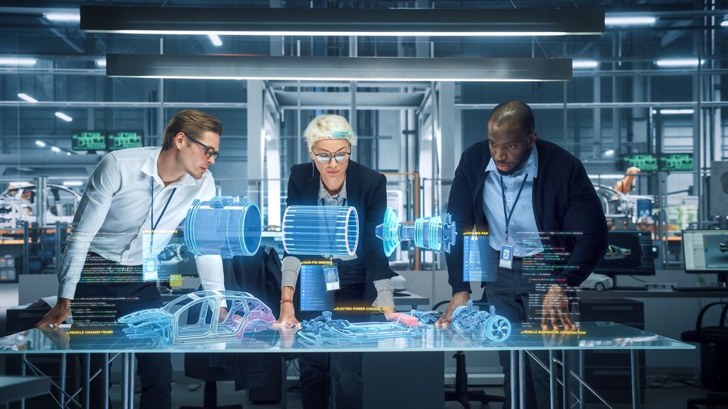 Tre personer står ved et glassbord hvor det er AR-hologrammer av en bil, ulike bildeler og tekstflater. Manipulert foto.
