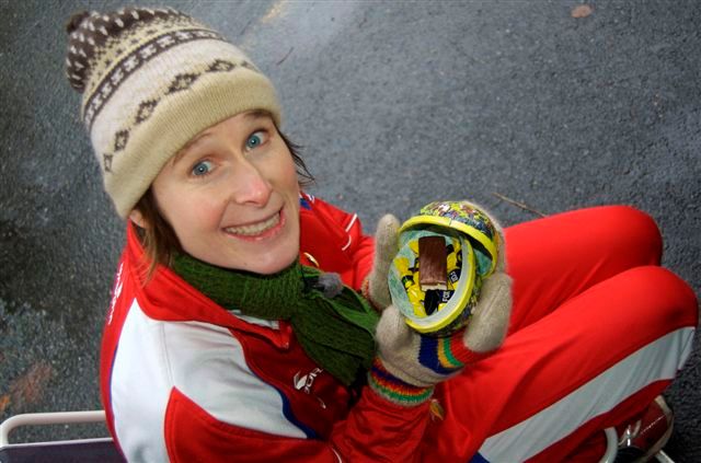 Linda Eide sit på huk i raud og kvit joggedress og held eit påskeegg med Fox-karamellar og sjokolade i. Foto.
