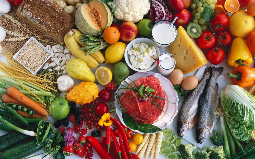 Ulike råvarer som grønnsaker, bær, frukt, fisk, kjøtt, egg og korn- og melkeprodukter lagt utover et bord. Foto.