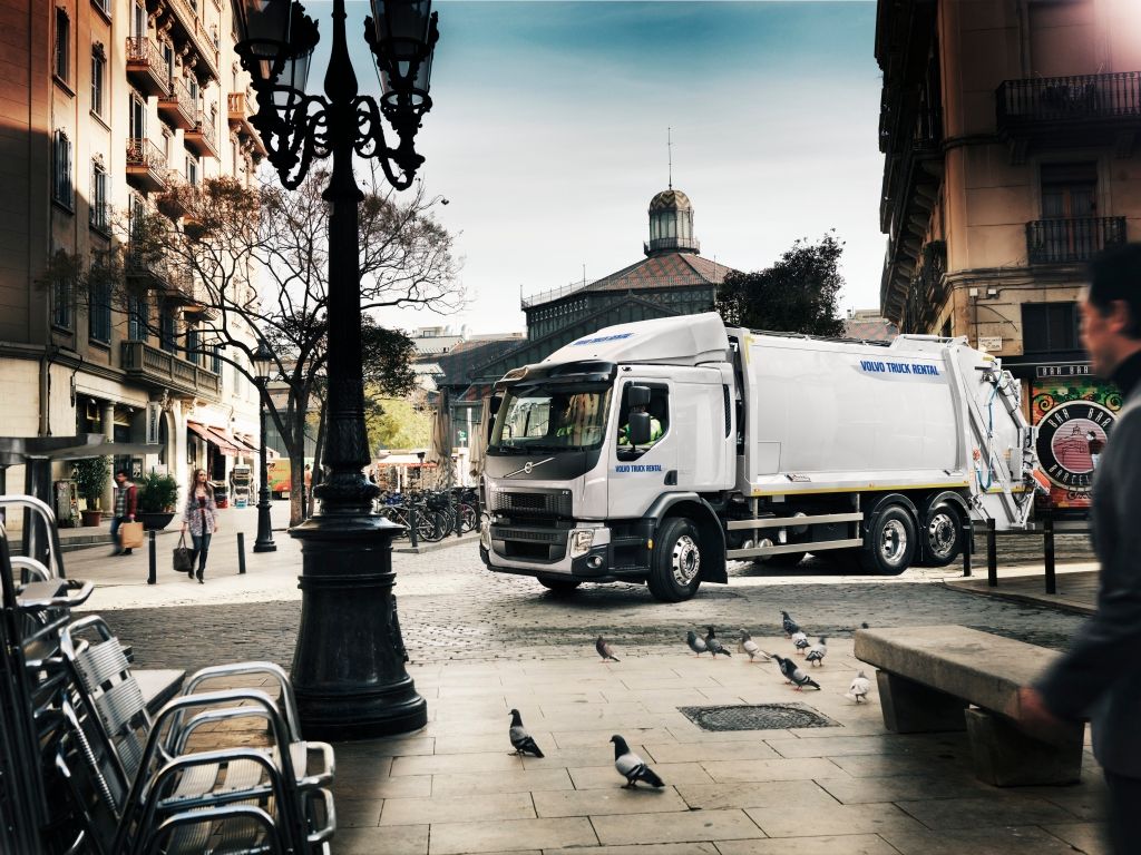 Bildet viser en renovasjonsbil i et bymiljø.