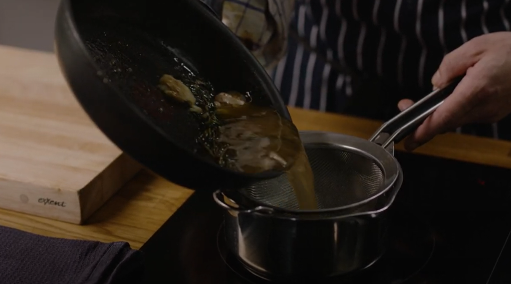 En sjysaus helles fra ei stekepanne og over i en kasserolle. Foto.