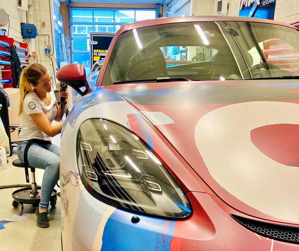 Fotografi av ei kvinne som dekorerer bil med folie.