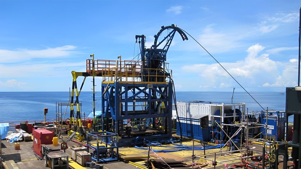 Kveilerøyrsutstyr montert saman på lukedekk over ein brønn. Foto.