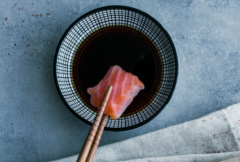 Laksebit dyppes i soyasaus. Foto.