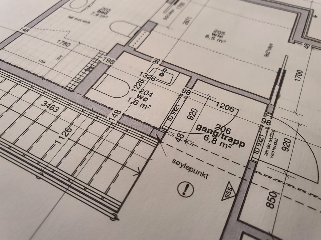 Teknisk tegning som viser forskjellige rom i en enebolig, blant annet wc og bad hvor også toalett og servant er tegnet inn. Illustrasjon.