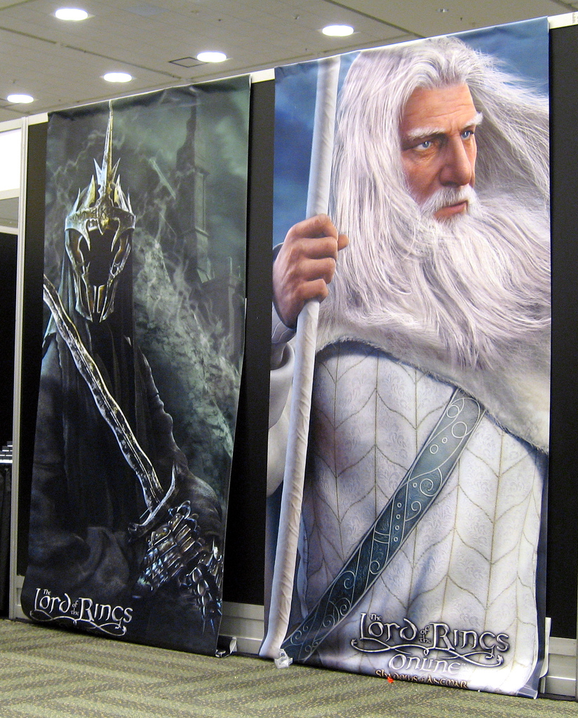 Filmplakater for filmen Ringenes herre med bilde av en svartkledd ansiktsløs kriger med sverd og en mann med hvitt hår og skjegg, hvit kjortel og hvit stav. Foto.