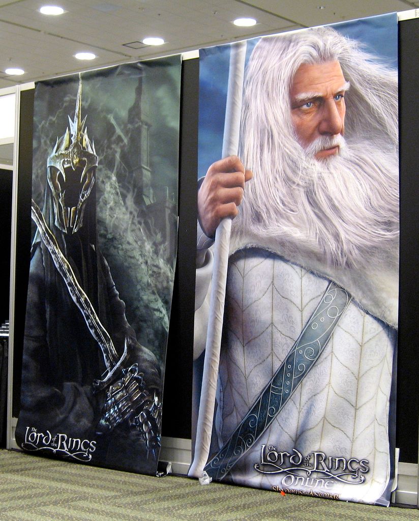 Filmplakatar for filmen Ringenes herre med bilete av ein svartkledd ansiktslaus krigar med sverd og ein mann med kvitt hår og skjegg, kvit kjortel og kvit stav. Foto.