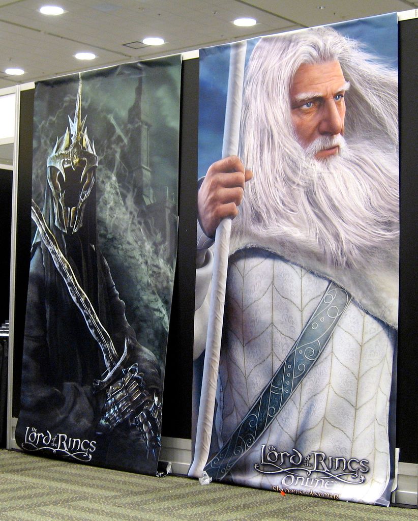 Filmplakater for filmen Ringenes herre med bilde av en svartkledd ansiktsløs kriger med sverd og en mann med hvitt hår og skjegg, hvit kjortel og hvit stav. Foto.