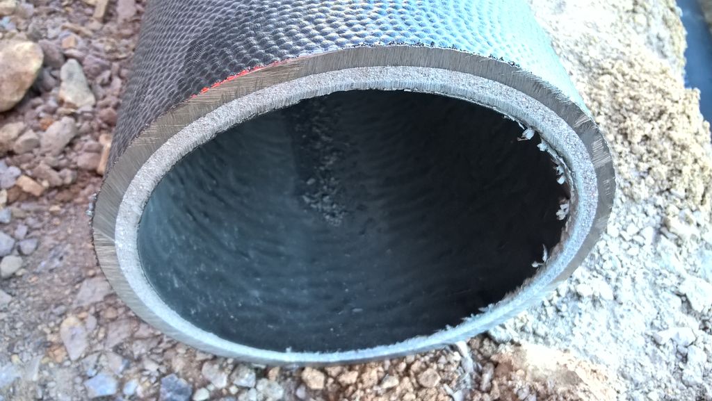 Gjennomskåret stålrør. Både innsida og utsida er belagt med et plastliknende materiale. Foto.