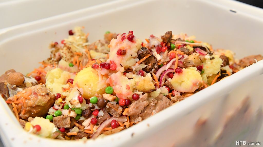 En beholder med mat som er kastet, blant annet poteter, kjøttkaker og erter. Foto.