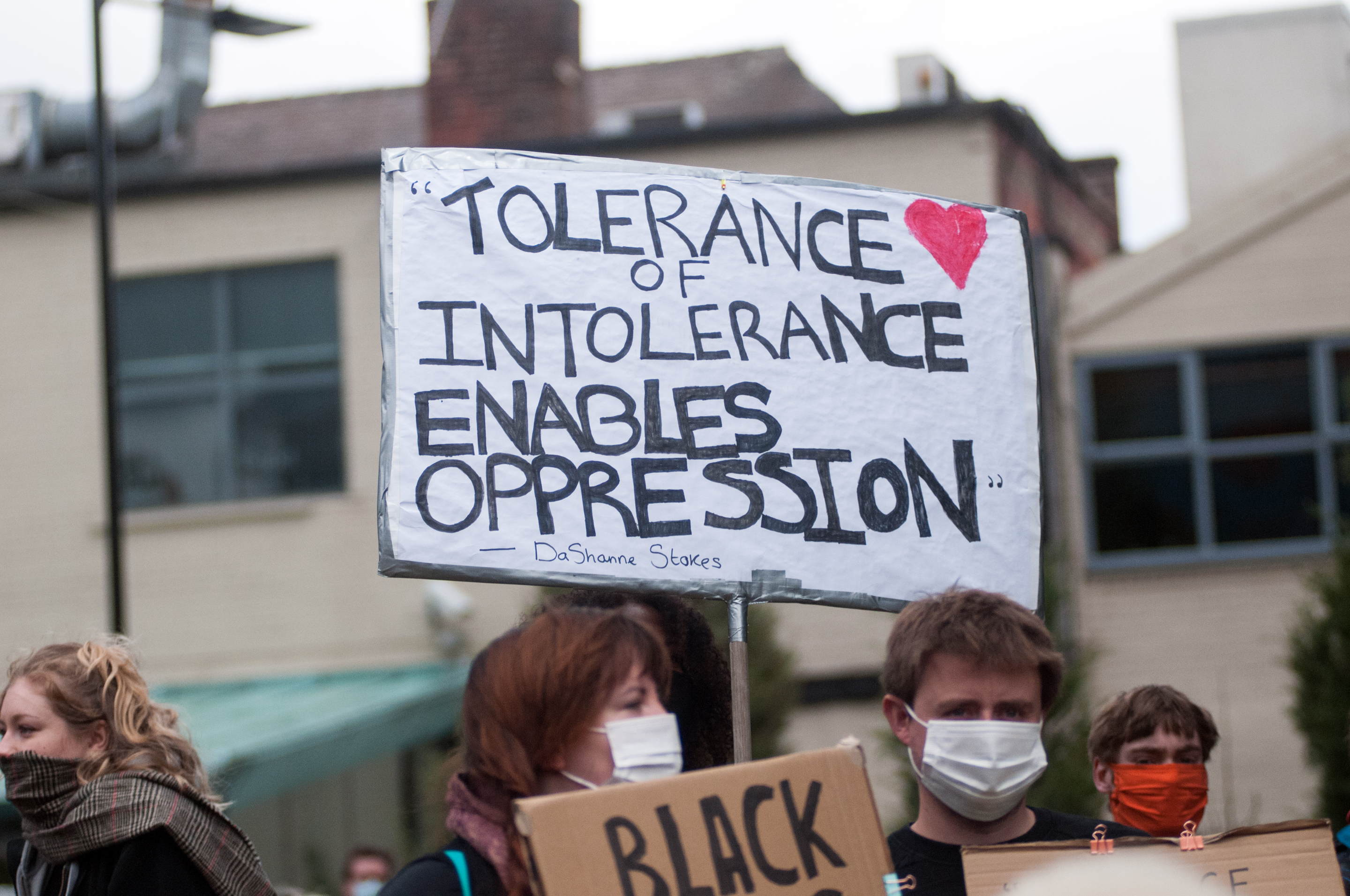 People holding a sign saying "Tolerance of intolerance enables oppression". Photo.