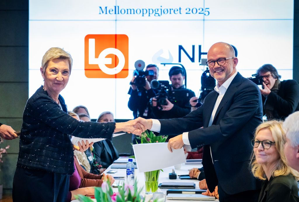 LOs leder og NHOs sjef hilser på hverandre fra hver sin side av bordet under åpningen av forhandlinger i 2019. Foto.