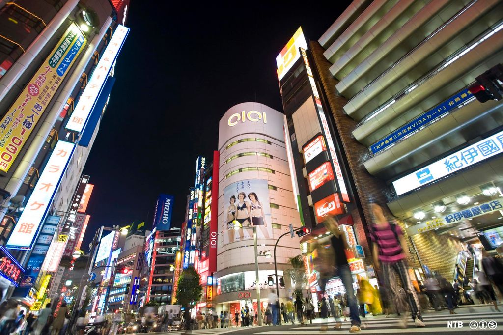 Tokyo sentrum om kvelden, med lysende bygninger og neonskilt. Foto.