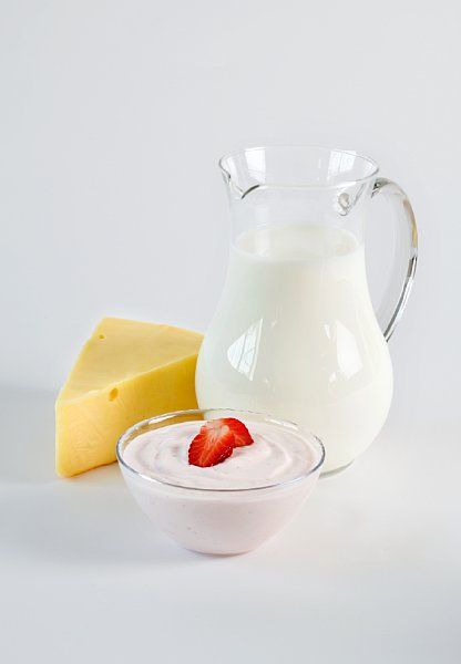 En mugge med melk, en skål med yoghurt og litt ost. Foto.