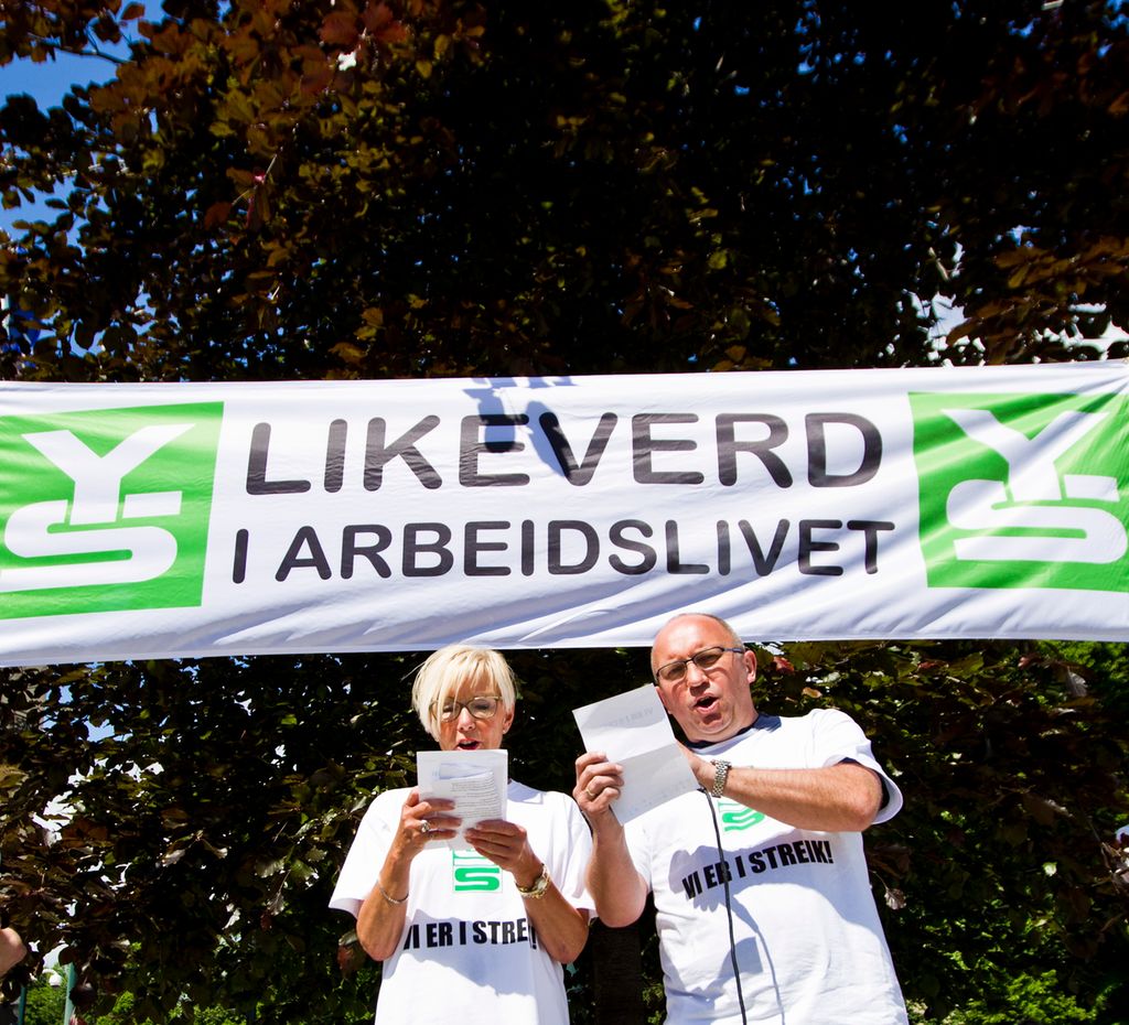 Arbeidstakerorganisasjonen YS i streik. To representanter med et banner som sier "Likeverd i arbeidslivet". Foto.