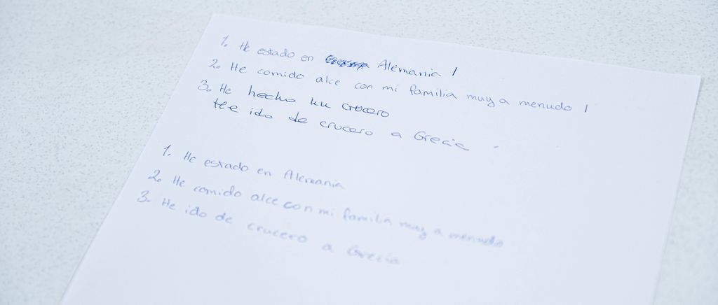 Noen håndskrevne spanske setninger på et hvitt ark. Foto.