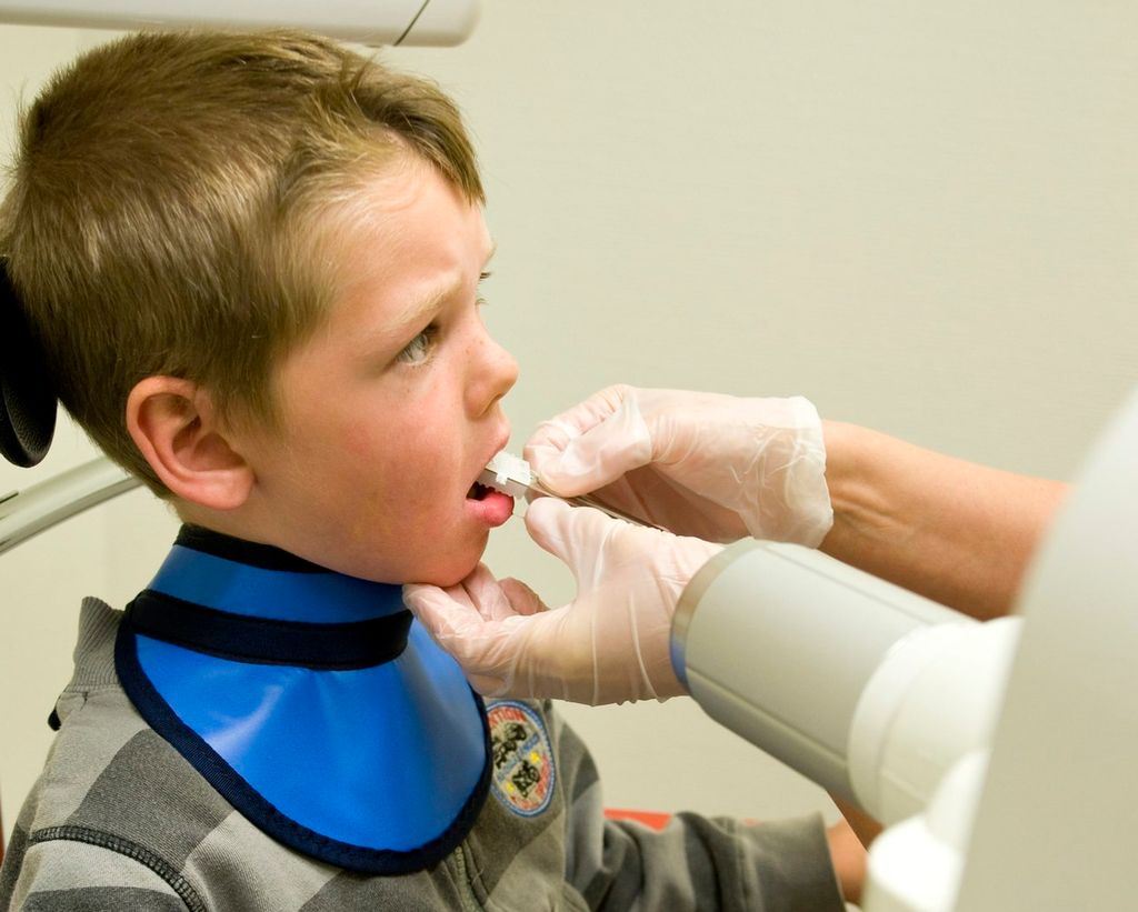 Et barn tar røntgenbilde hos tannlegen. Foto.