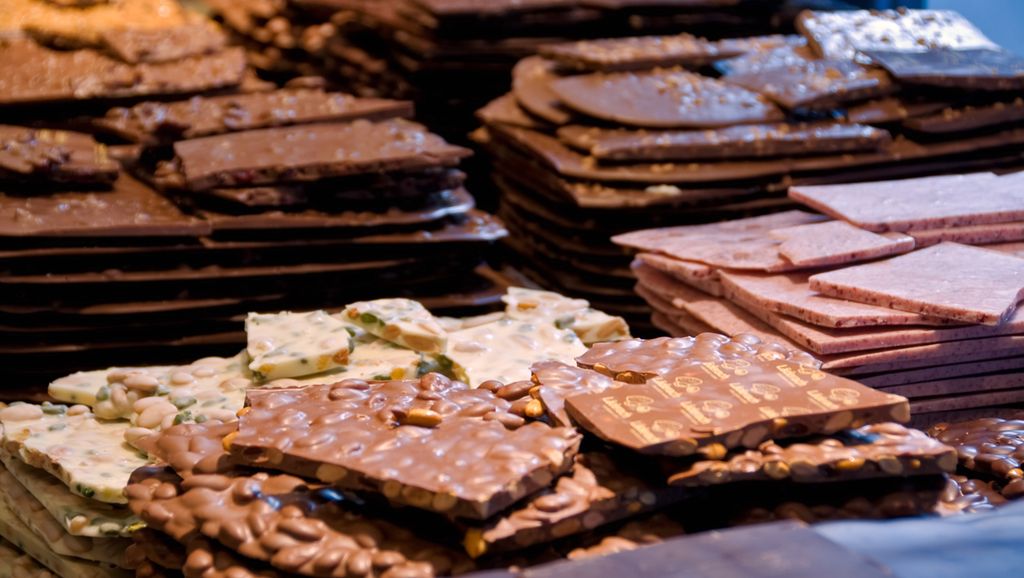 Store plater med ulike typer sjokolade stabla oppå hverandre. Foto.