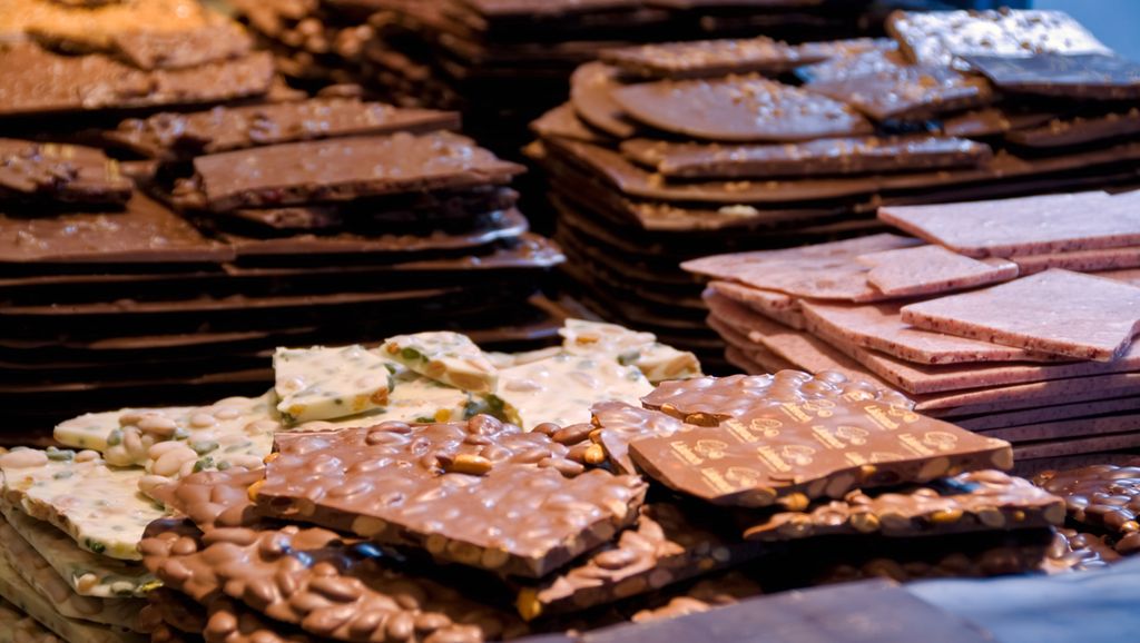 Store plater med ulike typar sjokolade stapla oppå kvarandre. Foto.