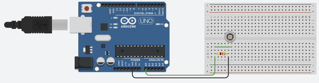 Arduino og et koplingsbrett der det er montert en fotodiode og en resistor. Komponentene er kopla sammen med ledninger. Illustrasjon.