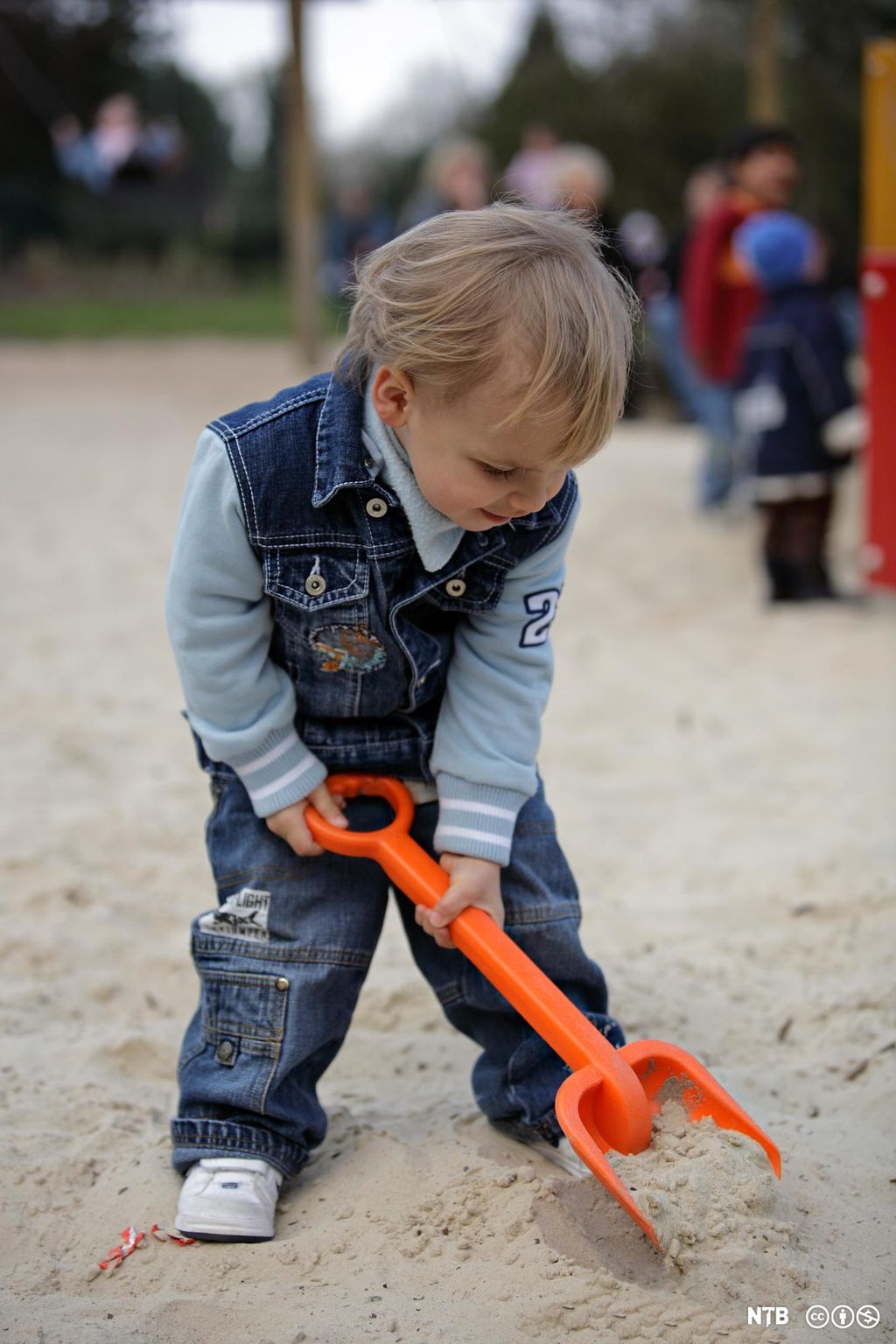 Liten gut leiker med spade. Foto.