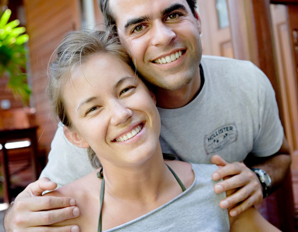 Nærbilde av en ung kvinne og en ung mann. Mannen holder rundt kvinnen. Begge smiler. Foto.