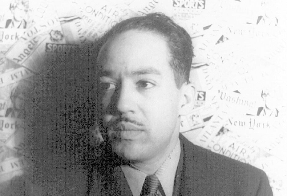 Photo: Langston Hughes is a middle aged man. He is wearing a suit. He has a thin moustach.