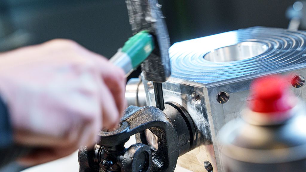 Hammer som slår på en sylindrisk konstruksjon. Foto.