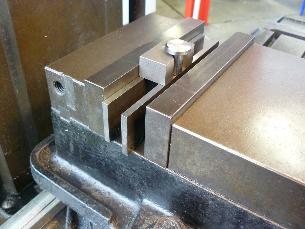 Maskinstikke montert på en fres. Et sirkelforma arbeidsemne står på parallellklosser og holdes på plass med spesialutstyr. Foto.