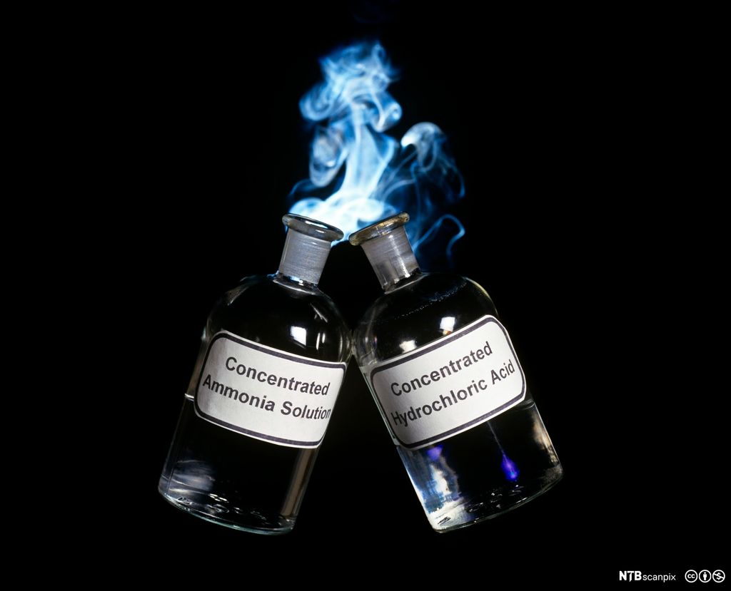 Dannelse av røyk når to glassflasker med væsker holdes med åpningene mot hverandre. Foto.