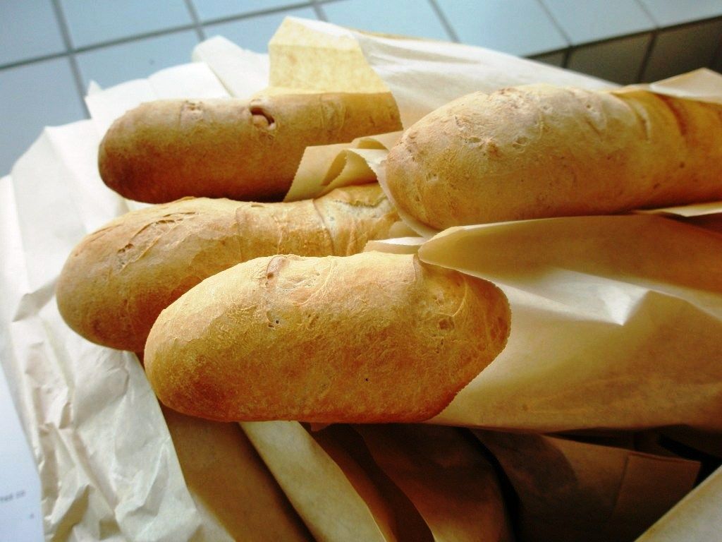 Bagetter i brune papirposer. Foto